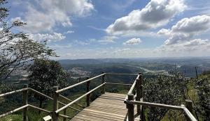 a wooden boardwalk with a view of a valley at Estilo Suíte in São Paulo