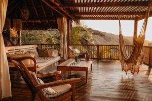 a porch with a couch and a table and chairs at Villa Del Sol in Máncora