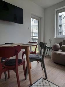 a living room with a table and chairs and a tv at Dębina Spot 27 in Debina