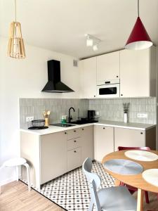 a kitchen with white cabinets and a wooden table at Dębina Spot 27 in Debina