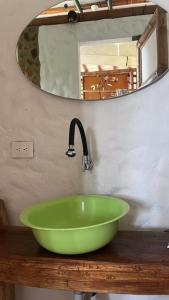 un bol vert sur un lavabo de salle de bain avec un miroir dans l'établissement Casa quinta con psicina, à Estación El Salto