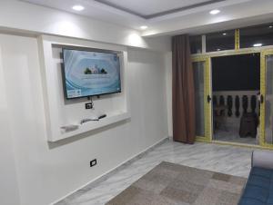 un salon avec une télévision à écran plat sur un mur dans l'établissement شقق الفندقية ميامي امام بئر مسعود, à Alexandrie 8 autres photos