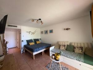 a living room with a couch and a bed at TI KAZ DOUDOU - village de vacances bord de mer in Sainte-Anne