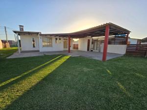 a house with a green lawn in front of it at A Pasitos Del Mar in Barra del Chuy
