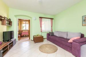 a living room with a purple couch and a tv at Seaside holiday house Igrane, Makarska - 24635 in Podgora