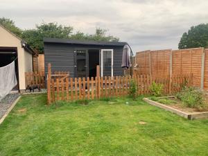 a backyard with a black shed and a fence at Sunnyside guest house in Latchingdon and Snoreham