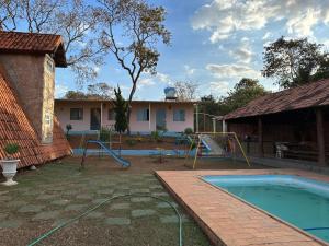 a backyard with a swimming pool and a playground at Chácara dos Azevedo in Divinópolis
