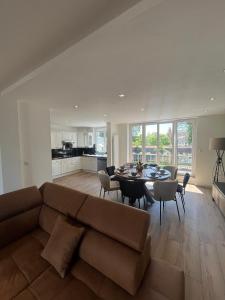 a living room with a couch and a table with chairs at Villa L'Etoile Du Littoral in Boulogne-sur-Mer