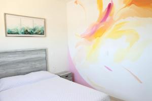 a bedroom with a bed and a painting on the wall at La Casa del Mural in Mixquiahuala