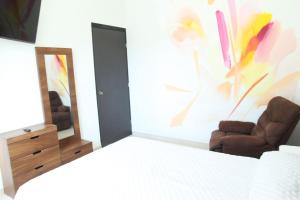 a bedroom with two chairs and a mirror at La Casa del Mural in Mixquiahuala +2 photos