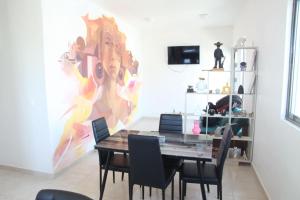 a dining room with a table and a painting on the wall at La Casa del Mural in Mixquiahuala