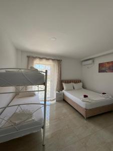 a bedroom with two bunk beds and a window at Villa Festim Ksamil in Ksamil