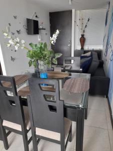 a dining room with a table and chairs and a couch at Vacaciones muy cerca al Parque del Cafe in Montenegro +3 photos