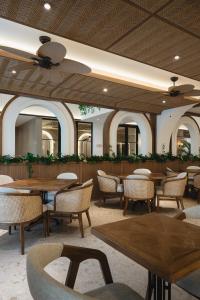 a dining room with tables and chairs and a ceiling at Hygge Hotel and Villas Seminyak in Seminyak