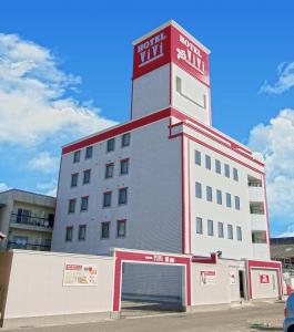 a white building with a red clock tower on top at 岐阜ホテルヴィヴィ in Gifu