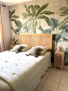 a bedroom with a large bed with a tropical wallpaper at Terracota - Spacieux et Chaleureux avec extérieur in Les Trois-Îlets