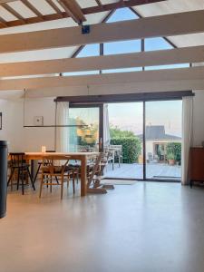 a dining room with a table and chairs and a large window at Beach House With Sauna By Norsminde Harbour in Malling