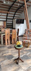 - une table avec des fleurs dans une pièce avec des chaises dans l'établissement Casa quinta con psicina, à Estación El Salto 7 autres photos