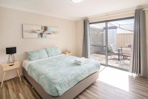 a bedroom with a bed and a balcony at Marina Family Beachscape in Geographe
