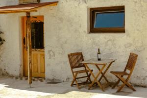 a table with two chairs and a bottle of wine at La casa de los árboles in Isla