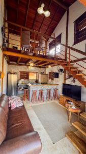 a living room with a couch and a kitchen at Pousada Reserva Setiba Guarapari in Guarapari