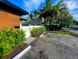 a driveway in front of a house with a white fence at SuaveMauve Las Olas Beach in Fort Lauderdale