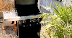 Hay una parrilla afuera en un patio. en Villa Luna Mare Ferienhaus mit Terrasse & Poolnähe, direkt am Meer, en Privlaka