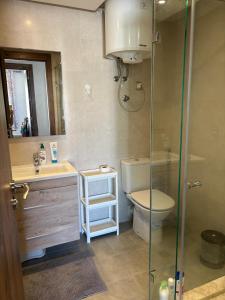 a bathroom with a toilet and a glass shower at Appartement vue piscine - Pour Famille - Blue Beach SIDI RAHAL in Sidi Rahal