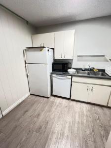 a kitchen with a white refrigerator and a sink at 3 Bedroom Apartment - 5 Beds in Abbotsford