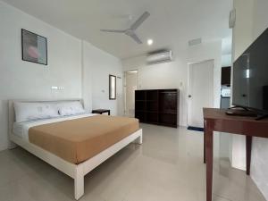 Un dormitorio con una cama y un televisor. en Lycanhikers Apartments, en Panglao