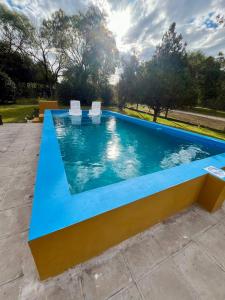 a pool with two white chairs sitting on top of it at Rincón del Sauce in Parana