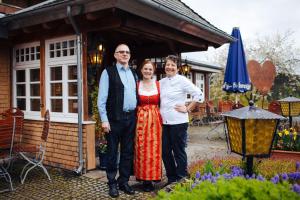 a man and a woman standing in front of a house at Hotel Adler Bärental in Feldberg