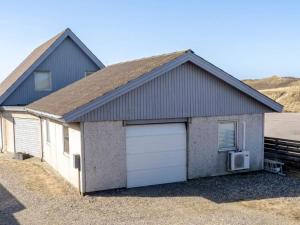 a large house with a garage with a car at 6 person holiday home in Vestervig in Vestervig