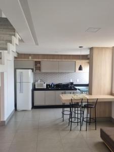 a kitchen with a table and chairs and a refrigerator at Apartamento Delineado in Ubá