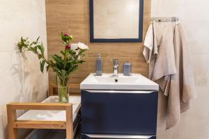 ein Badezimmer mit Waschbecken und einer Blumenvase in der Unterkunft Comfortable holiday cottages in Mielno in Mielno + 12 Fotos