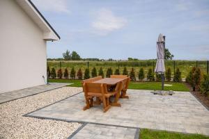 ein Tisch und Stühle und ein Sonnenschirm auf einer Terrasse in der Unterkunft Comfortable holiday cottages in Mielno in Mielno