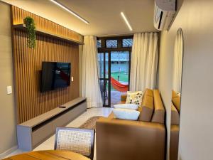 a living room with a couch and a tv at Encanto Moanara in Luis Correia