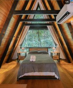 Ponte AltaにあるChalé Montem Verde I Serra Catarinenseのベッドと大きな窓のある寝室