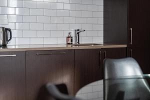 a kitchen with a sink and brown cabinets at The Stuart Street Terraced House in Dunedin +37 photos
