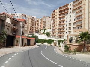 an empty street in a city with apartment buildings at Dar El Emir in Annaba