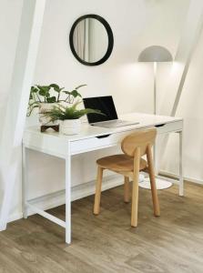a white desk with a laptop and a chair at Central Bargara Beach Bungalow by UG in Bargara