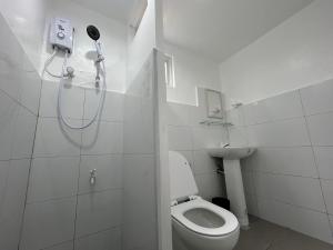Un baño blanco con ducha y WC. en Lycanhikers Apartments, en Panglao 13 fotos más