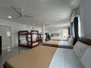 Un dormitorio con dos camas y un ventilador de techo. en Lycanhikers Apartments, en Panglao