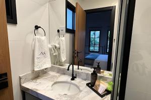 a bathroom with a sink and a mirror at Amora Maria Residencial in Cascavel +40 photos