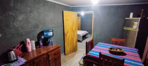 a kitchen with a table and a room with a bedroom at Casa Esquina in Tafí Viejo