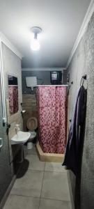 a bathroom with a toilet and a shower curtain at Casa Esquina in Tafí Viejo