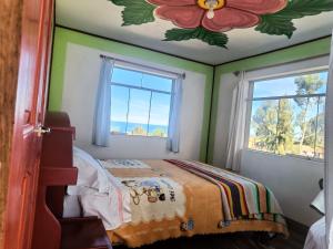 a bedroom with a bed with a flower painted on the ceiling at Kantuta T'ika Lodge in Isla Amantani