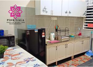 a kitchen with a black refrigerator and a sink at Inap Homestay Kuantan - 5 minutes from Balok Beach by PG Management in Kampong Tanjong +7 photos