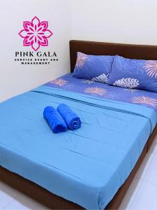 a bed with blue sheets and pillows in a room at Inap Homestay Kuantan - 5 minutes from Balok Beach by PG Management in Kampong Tanjong