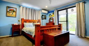a bedroom with blue walls and a bed and a window at Misty River in Macksville